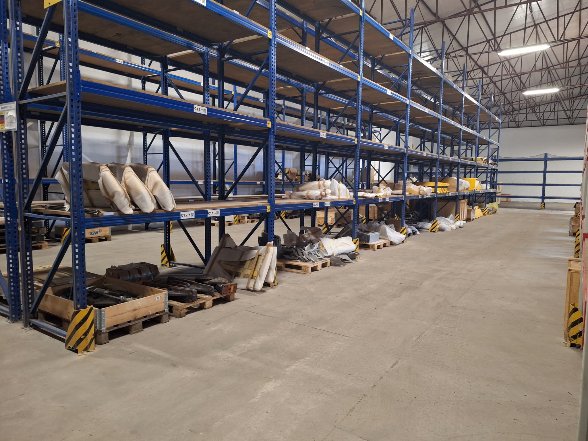Close-up of blue shelving holding boxed and wrapped rail components ready for dispatch